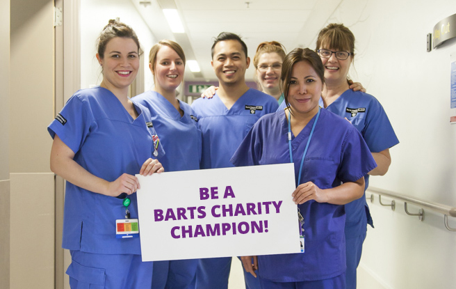 CHARITY CHAMPION Hospital staff holding sign that says 'Be a Barts Charity Champion!'