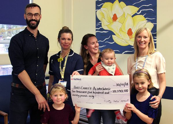 Fundraising family holds cheque for Barts Charity
