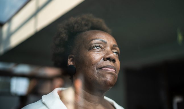 Senior woman looking through the window