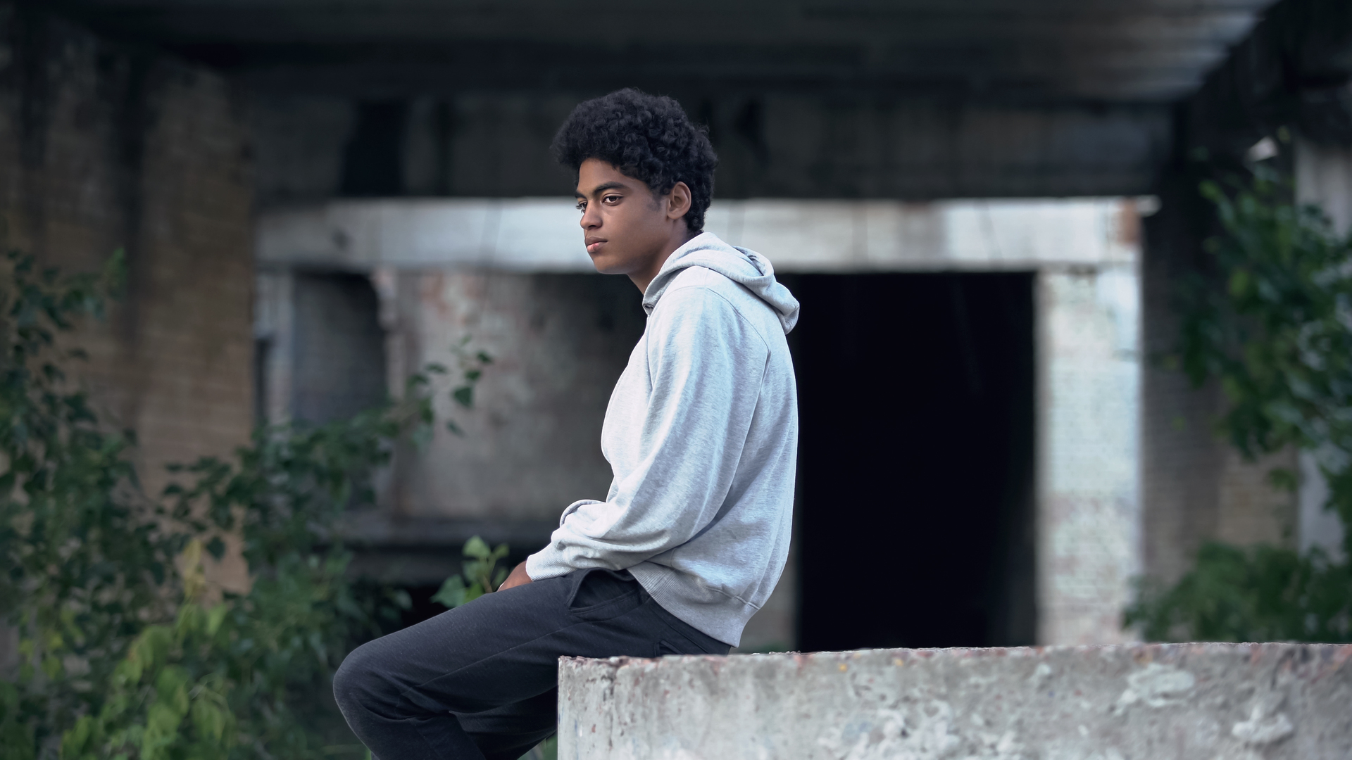 Depressed lonely male sitting on abandoned building