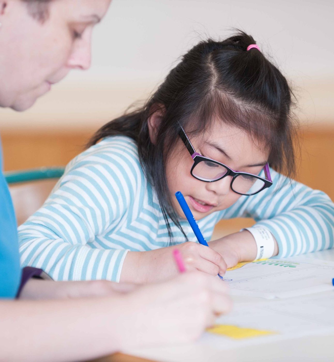 a child drawing with a member of the Play Team at The Royal London Hospital