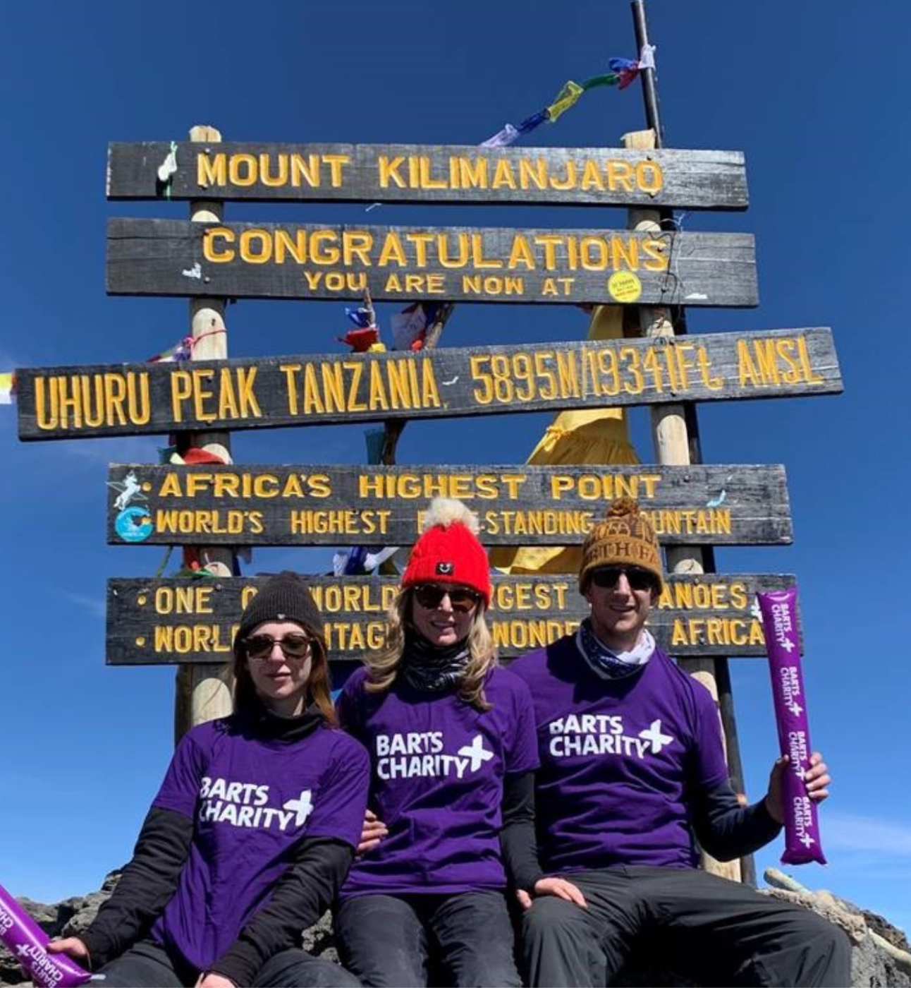 Fundraisers sitting at the top of Mount Kilimanjaro
