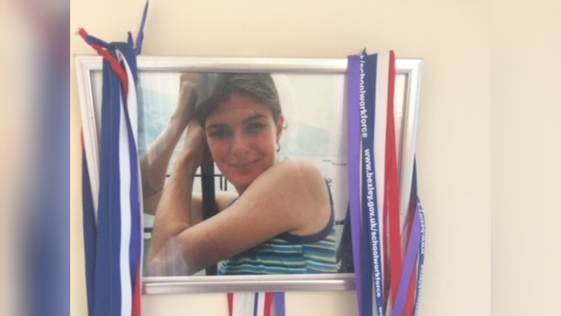 A photo of Sarah Hammond, with lots of medals hanging on the edge of the frame