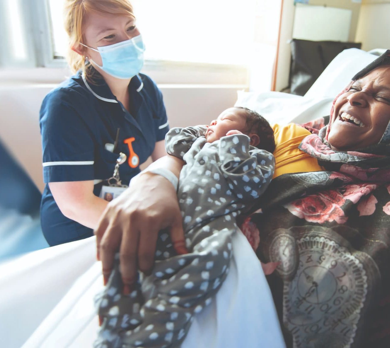 Nurse sitting with woman and baby