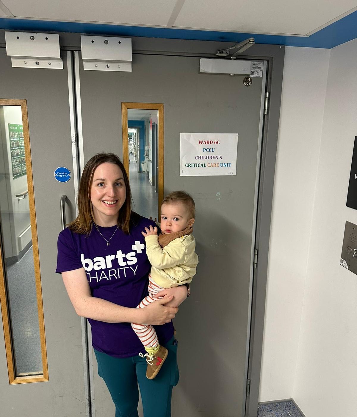 Mother holding her child in a hospital ward, both smiling