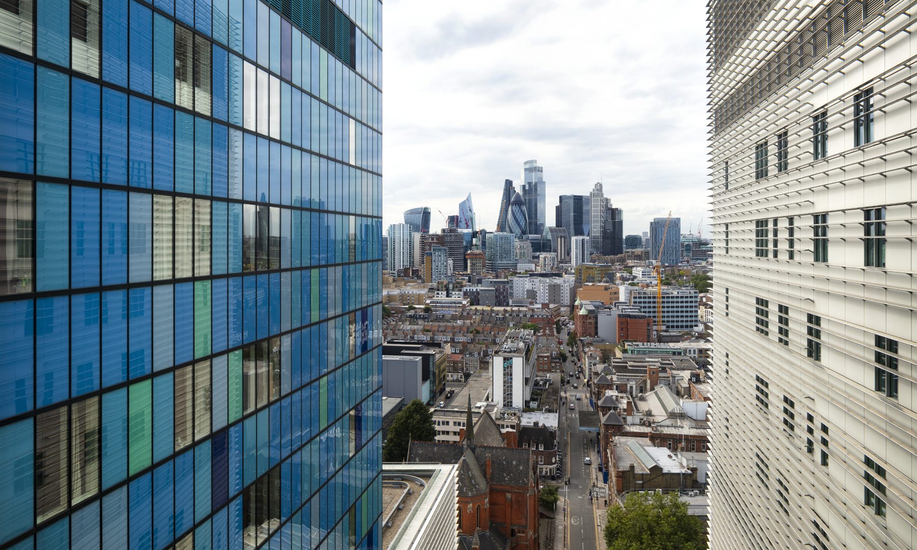 Skyline view between The Royal London Hospital. Canary Wharf can be seen in the distance.