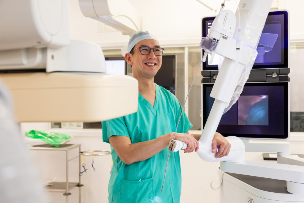 Surgeon Kelvin Lau with robot