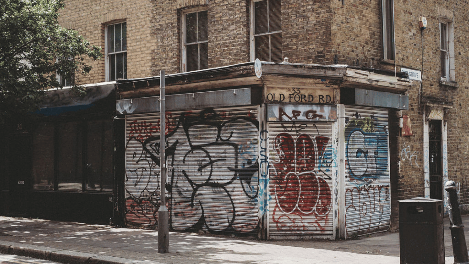 A corner on a street with walls covered in graffiti.