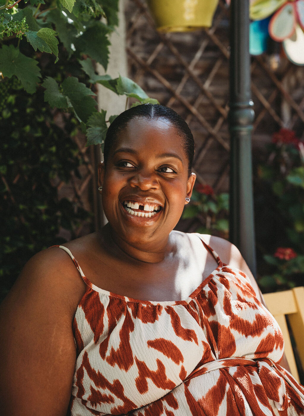 A close-up of a woman smiling, looking away from the camera