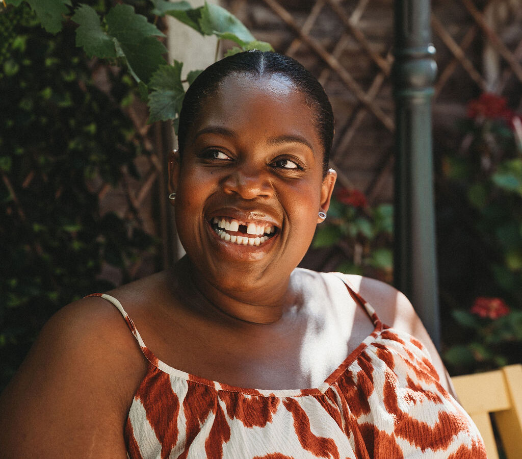A close-up of a woman smiling, looking away from the camera